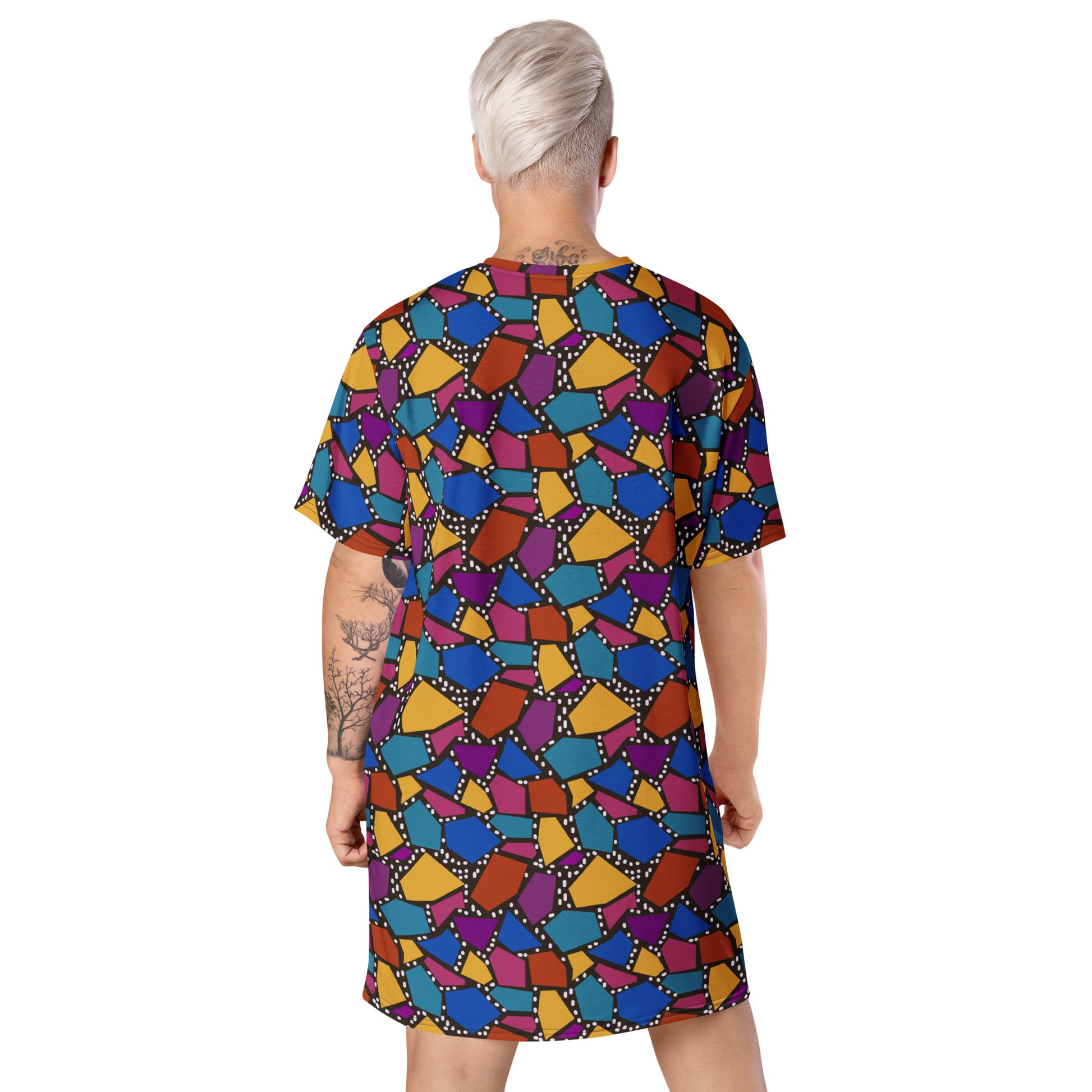 Striking geometric patterned t-shirt dress in a vibrant futuristic Synthwave colour palette against a black and white dotted background. Available here in a muted rainbow style.