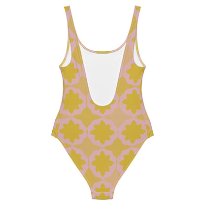 This cheeky, nude-toned and comfortable, abstract design patterned one-piece swimsuit is entitled Geometric Flock and consists of a colorful, abstract geometric floral design in pink and yellow/orange tones