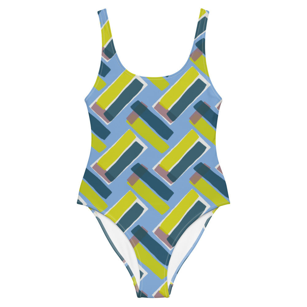 This cheeky, stylish and comfortable, abstract design patterned swimsuit is entitled Forever Connected and consists of diagonal color blocks in an alternating criss-cross format on a cerulean blue background