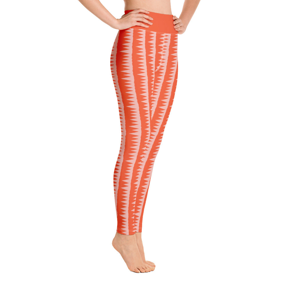 This Mid-Century Modern style yoga leggings pattern consists of colorful pink jagged columns of geometric triangular shapes stacked upon each other like columns against an orange red background. The high waistband is kept simple, picking out the vibrant orange color in these distinctive patterned yoga tights.