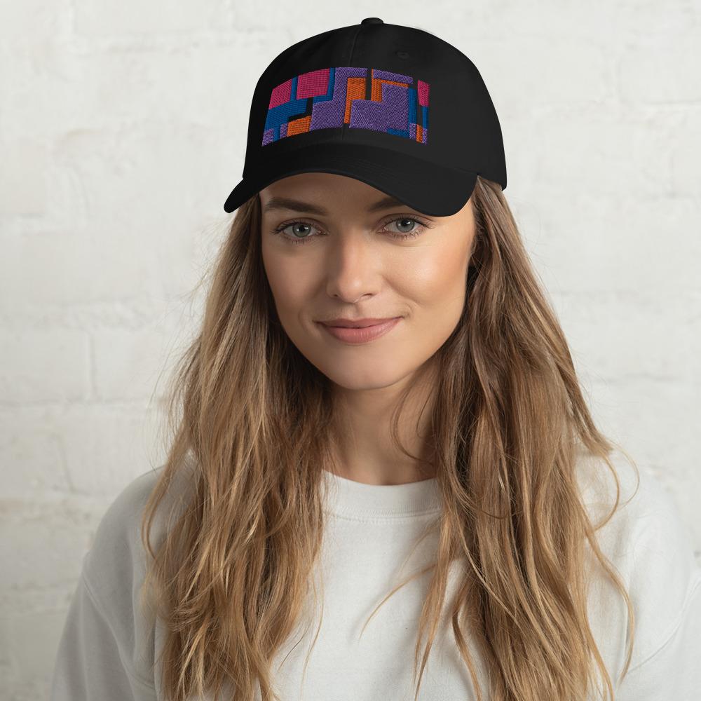 Colorful pink, orange, purple and blue geometric shapes patterned rectangular logo on this black colored dad hat