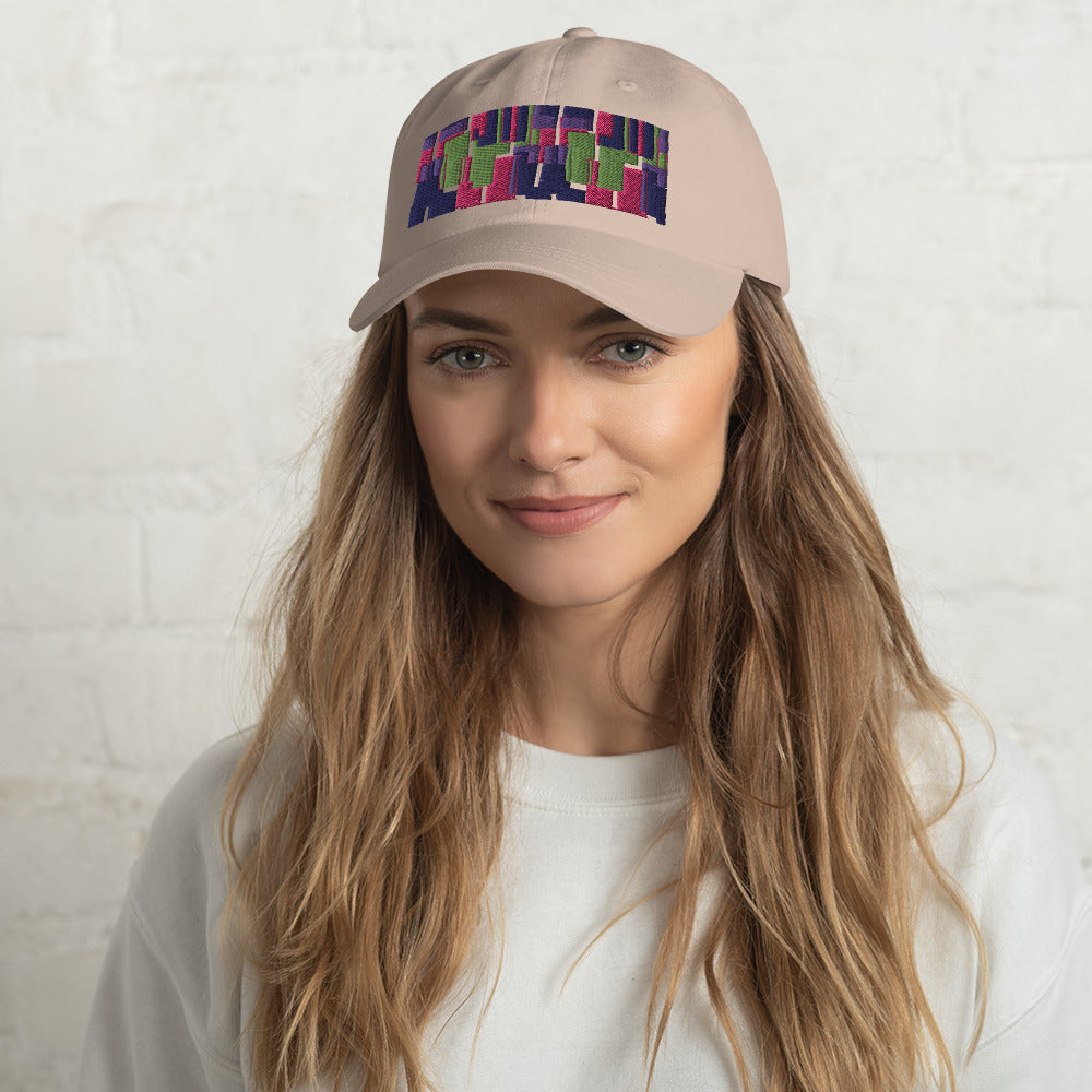 Stone colored dad hat with retro 60s style geometric pattern logo in threads of lime green, pink, purple and indigo