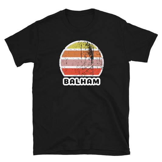 Vintage retro sunset in yellow, orange, pink and scarlet with the name Balham beneath on this black t-shirt